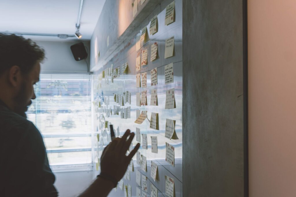 Person adding sticky notes to a wall.