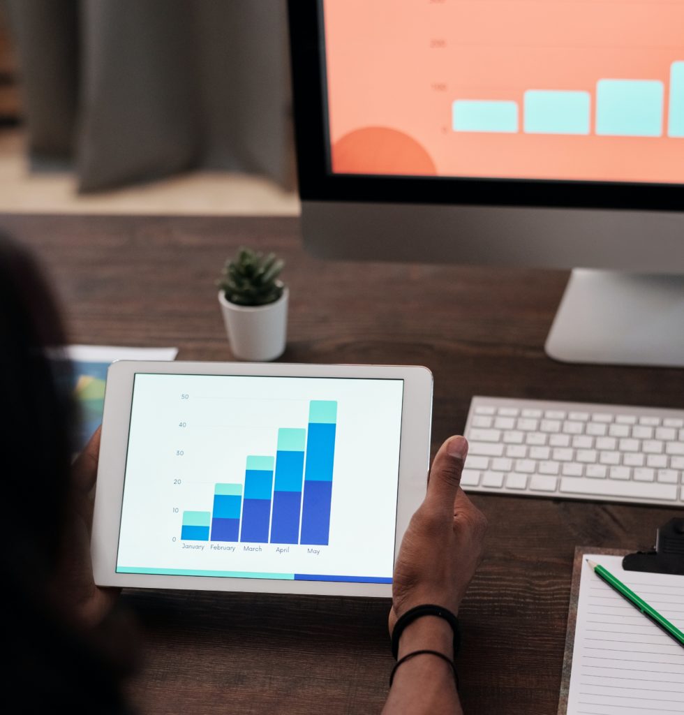 Person holding a tablet that shows a graph.