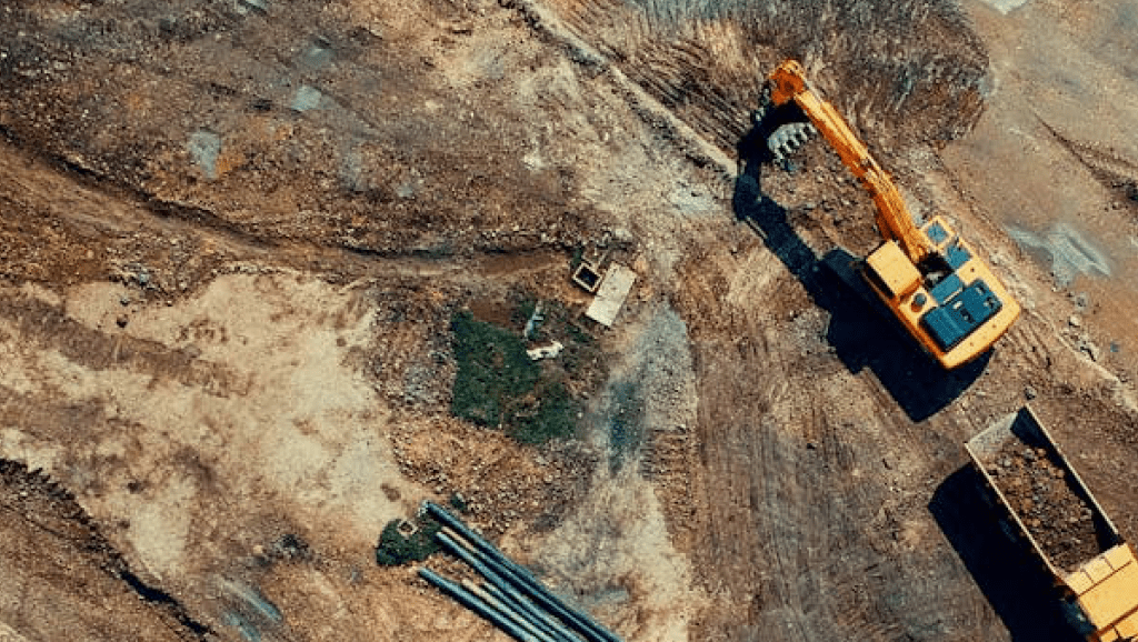 Aerial photograph showing trucks working on road.
